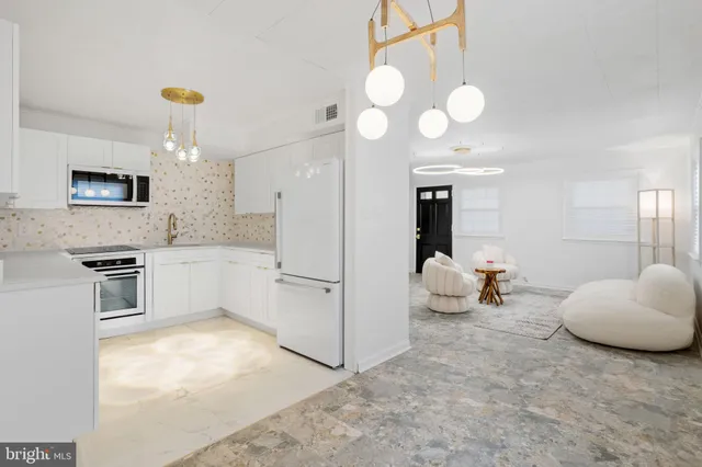a kitchen with cabinets and chairs