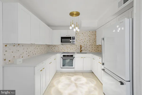 a kitchen with granite countertop a sink stove and refrigerator