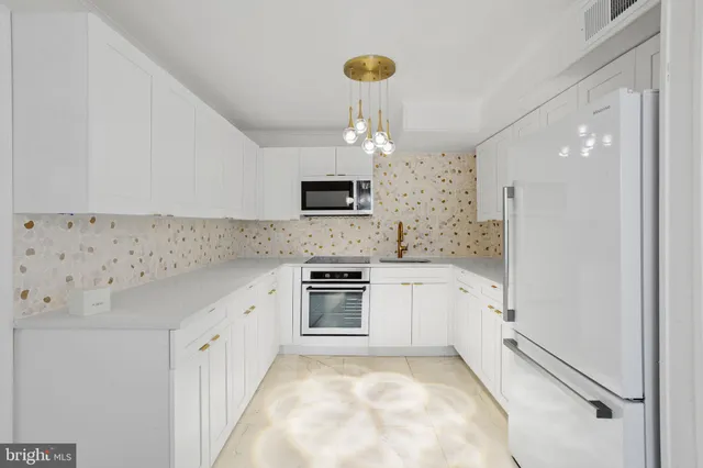 a kitchen with granite countertop a sink stove and refrigerator