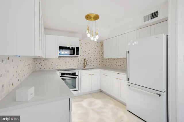 a kitchen with stainless steel appliances granite countertop a refrigerator and a stove top oven