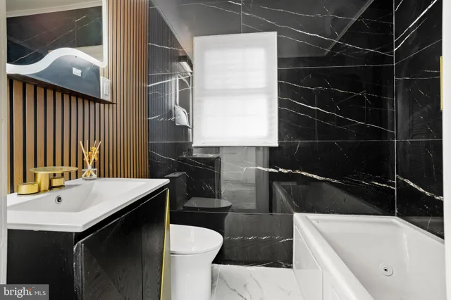 a bathroom with a sink a toilet and bathtub