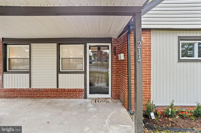 a view of a porch with a floor to ceiling window and potted plants