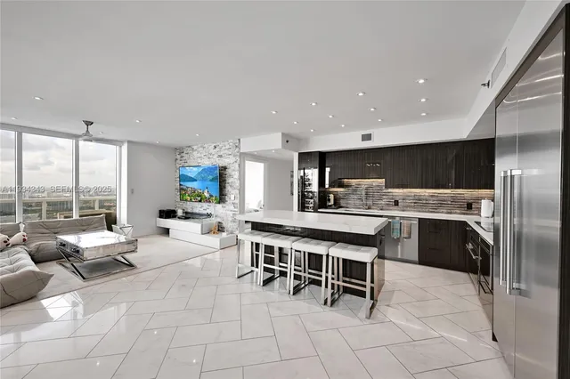 a kitchen with stainless steel appliances a table and chairs in it