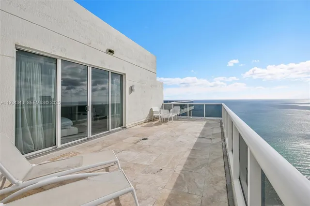 a view of balcony with two chairs and floor to ceiling window