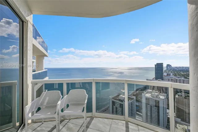 a living room with furniture and floor to ceiling windows