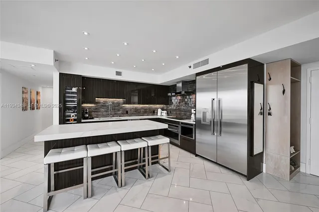 a kitchen with stainless steel appliances granite countertop a refrigerator and a stove top oven