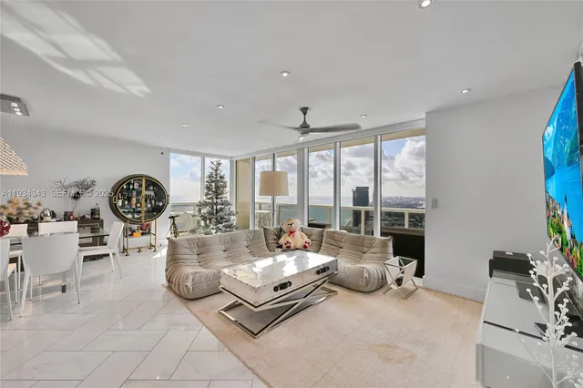 a living room with furniture and floor to ceiling windows