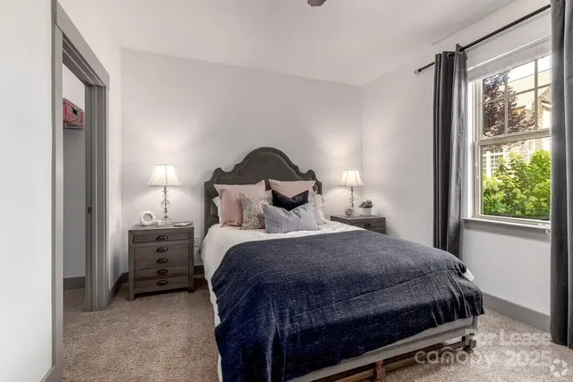 a bed sitting in a bedroom next to a window