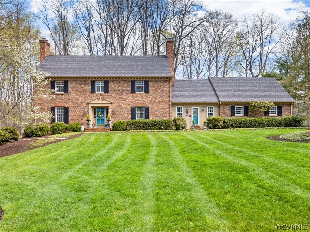a front view of a house with a yard and trees