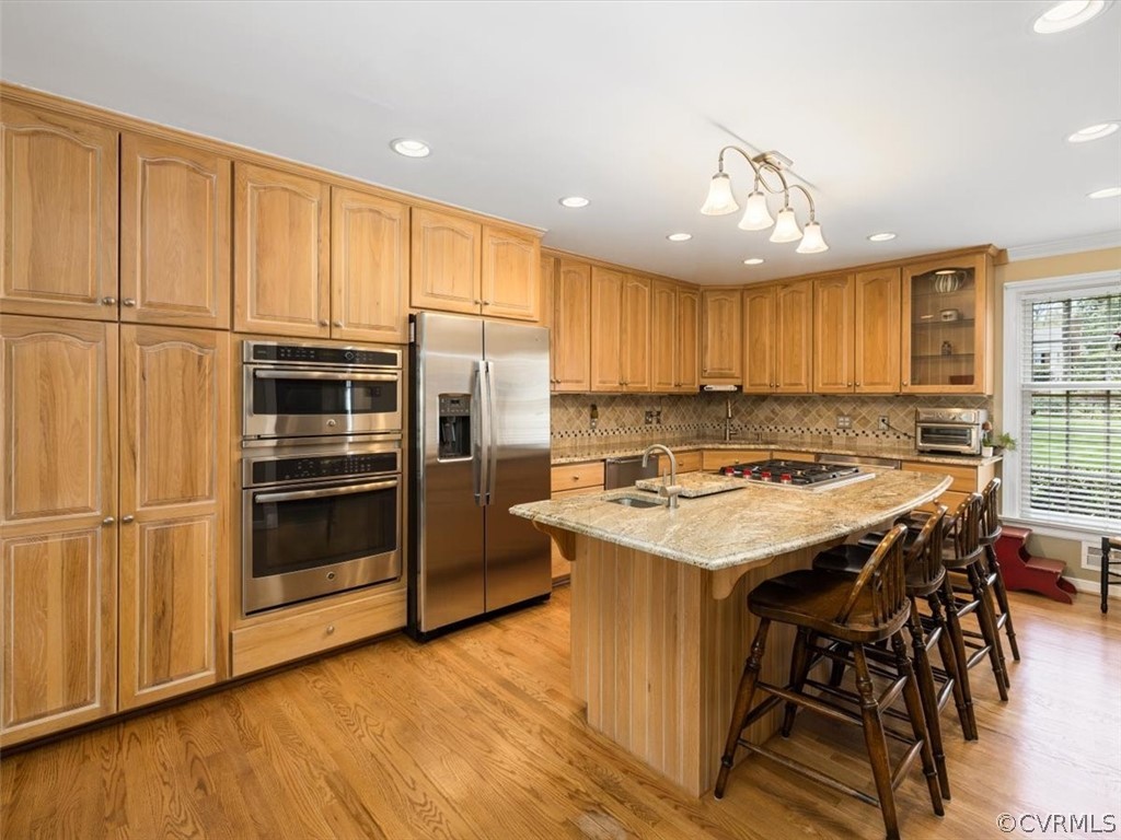 2931 West Brigstock Road Midlothian, VA 23113 - Photo 5 of 46 a kitchen with kitchen island granite countertop wooden cabinets and stainless steel appliances