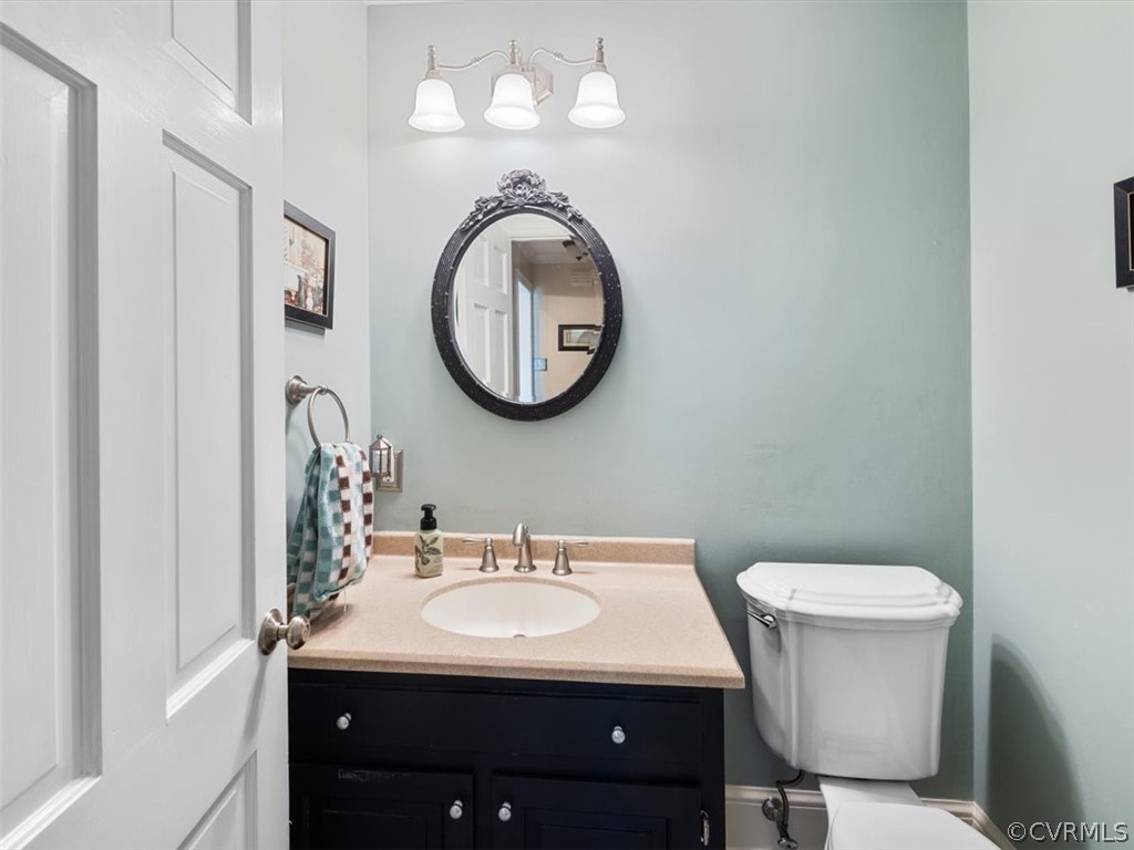 2931 West Brigstock Road Midlothian, VA 23113 - Photo 10 of 46 a bathroom with a toilet a sink and mirror