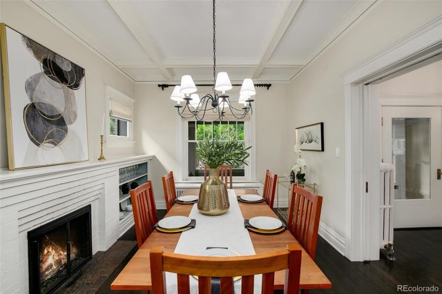 a view of a dining room with furniture a chandelier and wooden floor