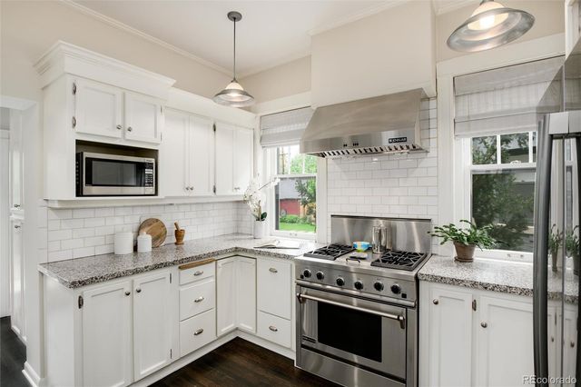 a kitchen with granite countertop a stove and a sink