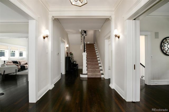 a view of a hallway with wooden floor and stairs