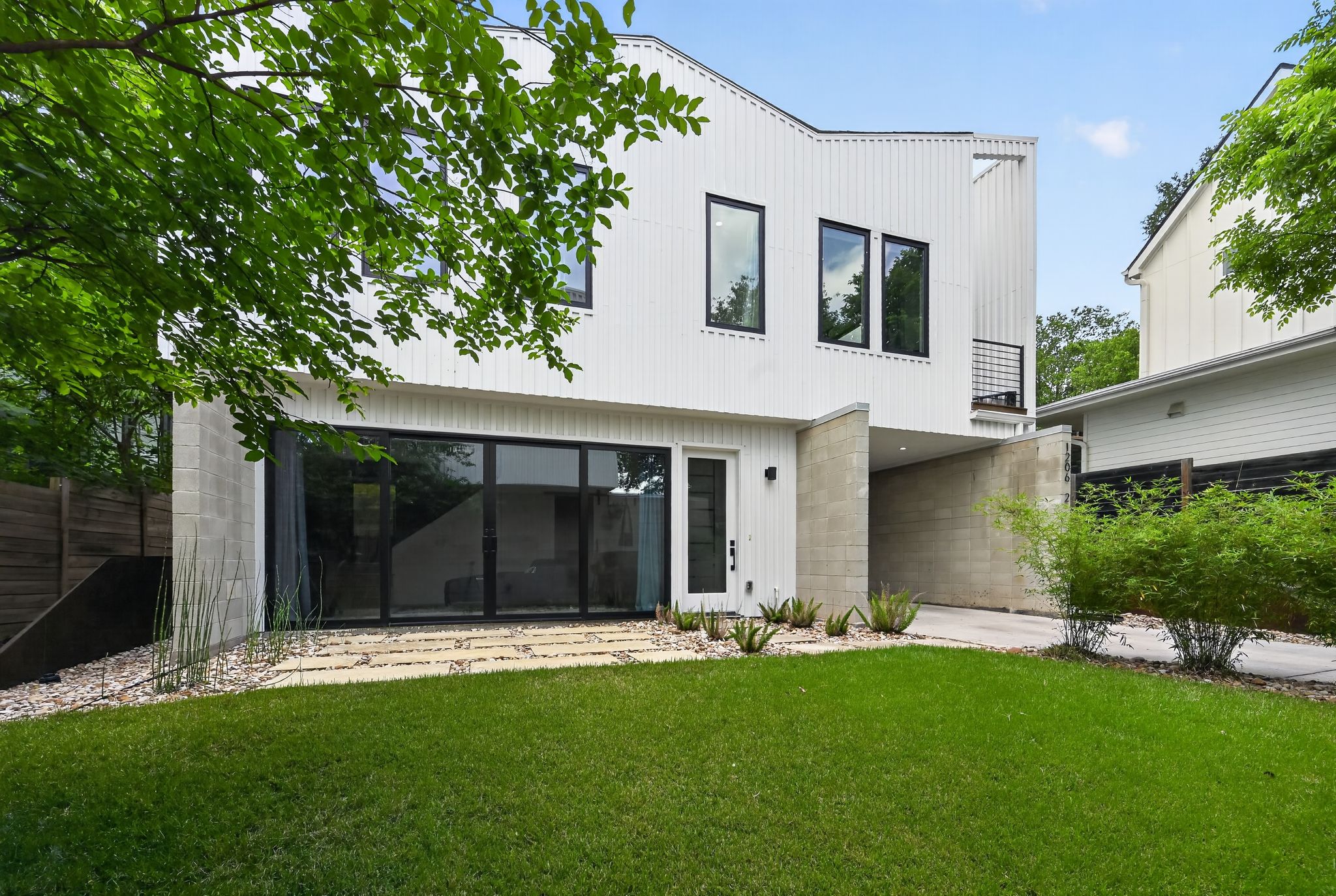 1206 Luna Street, Unit 2 Austin, TX 78721 - Photo 4 of 30 Contemporary property with a white exterior, a spacious lawn, and an integrated carport