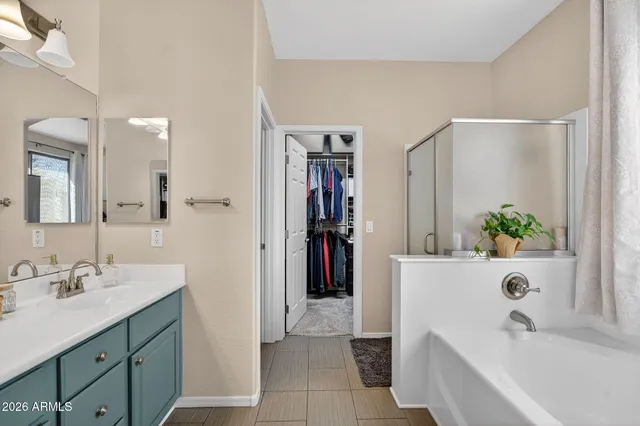 a patio with table and chairs with potted plants and a big yard