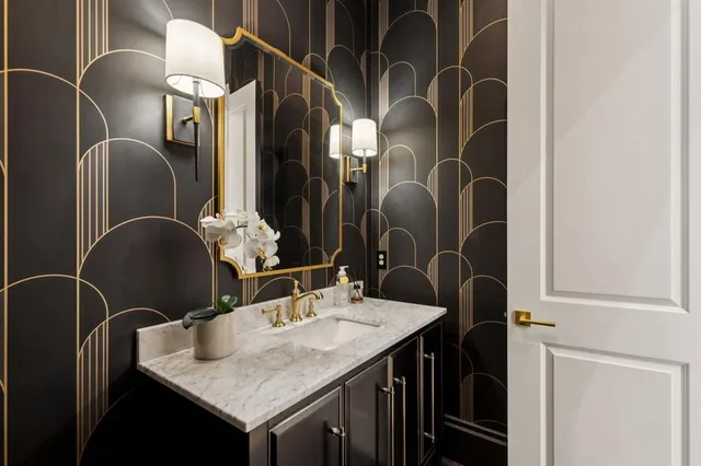 a bathroom with a granite countertop sink a mirror and shower