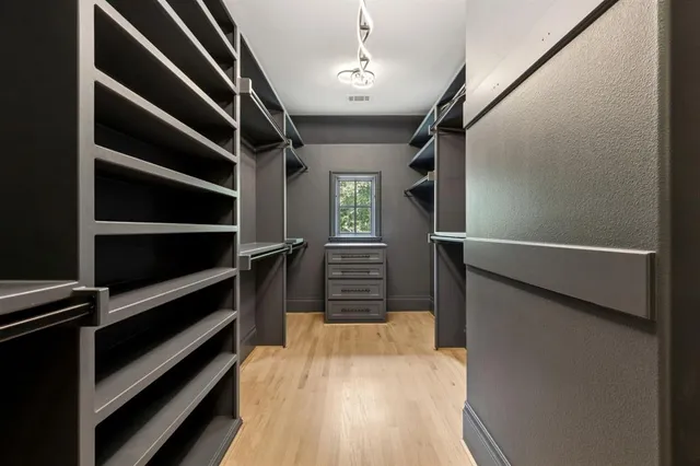 a view of walk in closet with empty racks