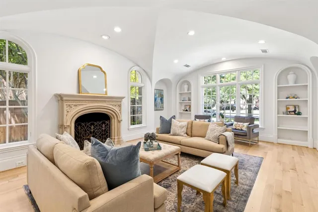 a living room with furniture fireplace and large windows