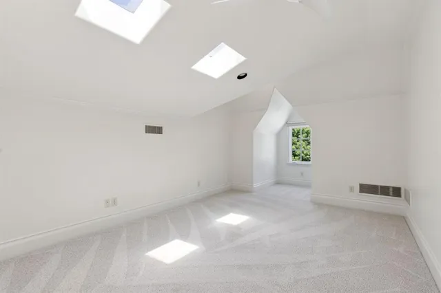 an empty room with a window and a ceiling fan