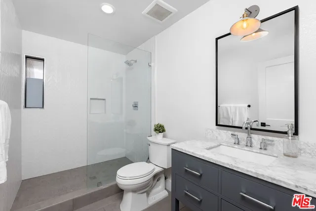 a bedroom with furniture a flat screen tv and a large window