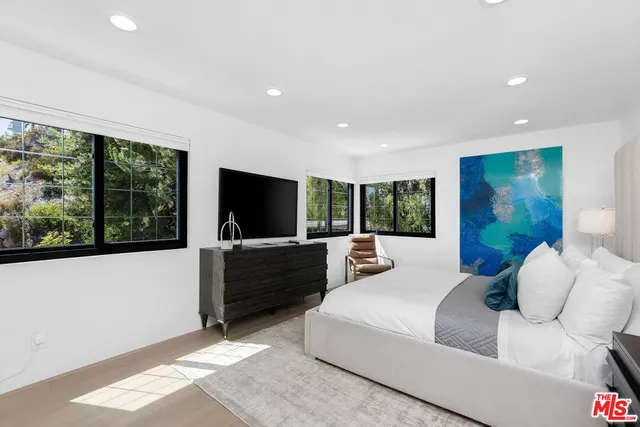 a spacious bedroom with a large bed and a large window