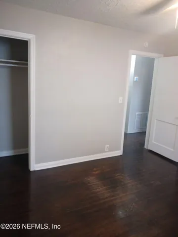 an empty room with wooden floor and closet