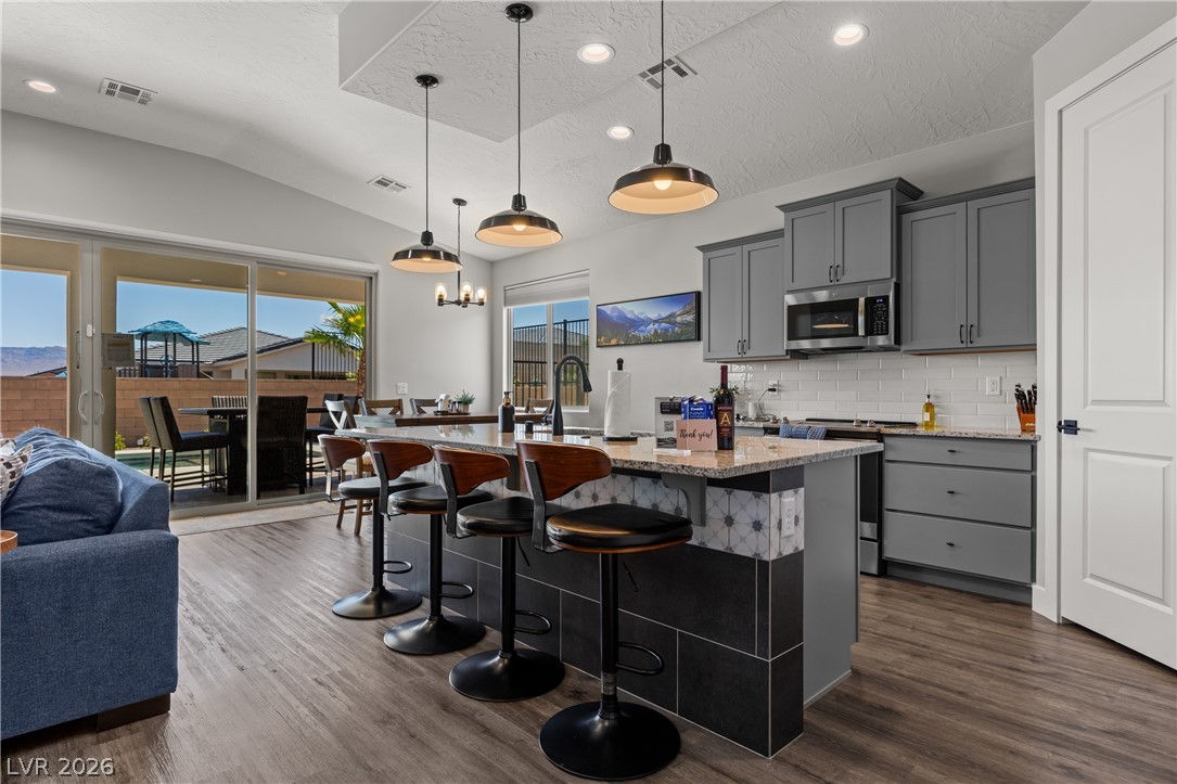 1436 Manassas Ridge Mesquite, NV 89027 - Photo 25 of 77 An open-concept living space integrates a well-appointed kitchen with an inviting dining area, flowing seamlessly to outdoor leisure.