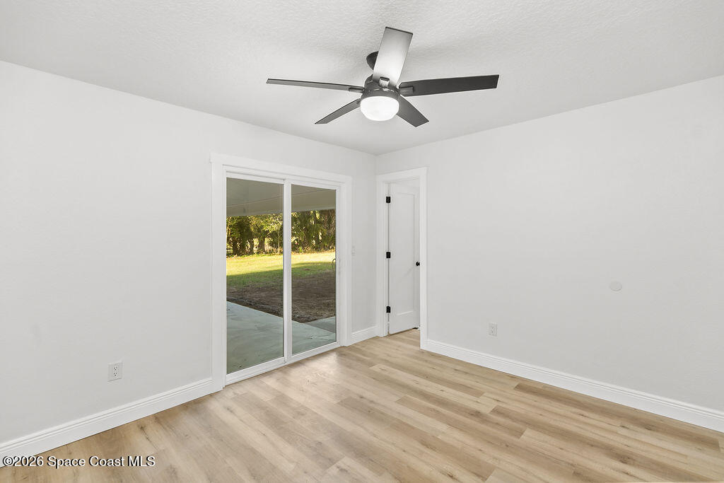 1815 Ford Road Mims, FL 32754 - Photo 27 of 59 an empty room with a ceiling fan and windows