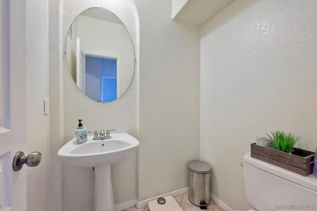 a bathroom with a toilet a sink and mirror