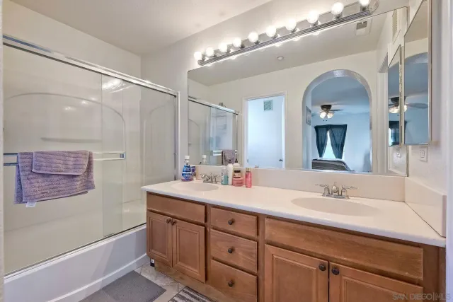 a en suite bathroom with a double vanity sink and a mirror
