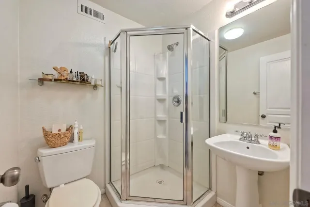a bathroom with a shower a sink and a toilet