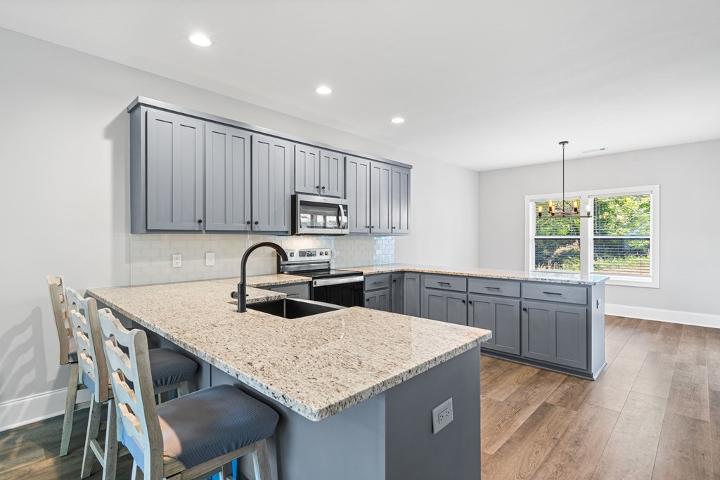 91 Dewey Ridge Lane Hayesville, NC 28904 - Photo 18 of 40 a kitchen with granite countertop a table chairs in it and wooden floors