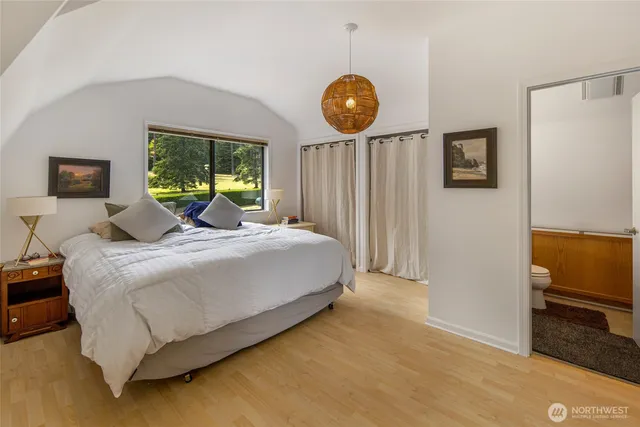 a bedroom with a bed and a flat tv screen on dresser