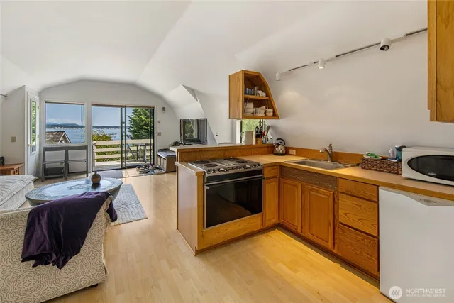 a kitchen with stainless steel appliances granite countertop a stove a sink and a refrigerator