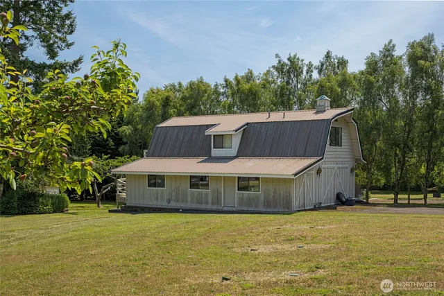 a front view of a house with a yard and trees