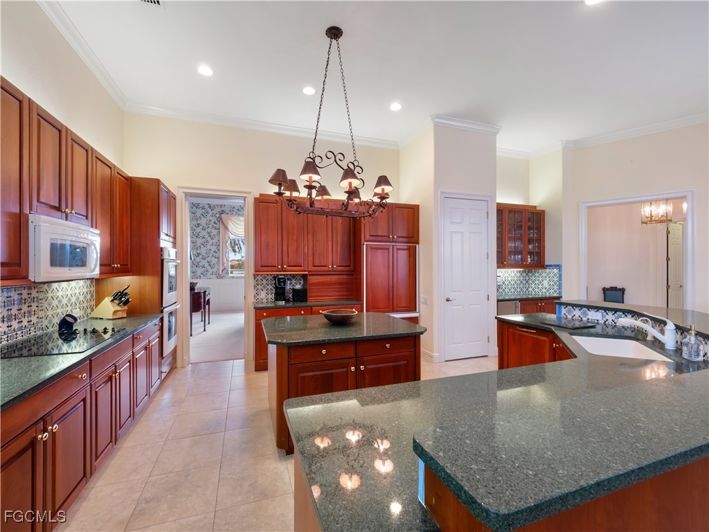 11511 Compass Point Drive Fort Myers, FL 33908 - Photo 10 of 46 a kitchen with kitchen island granite countertop a stove and a sink
