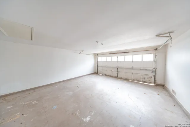 an empty room with a ceiling fan and window