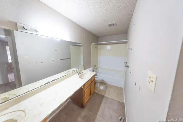a bathroom with a granite countertop sink a mirror and a bathtub