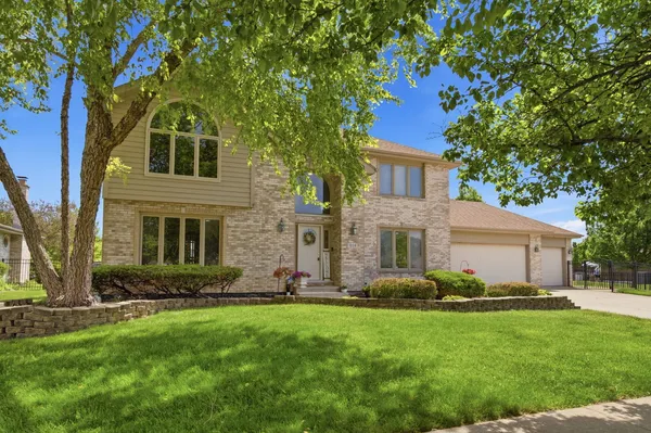 a front view of a house with a yard and trees