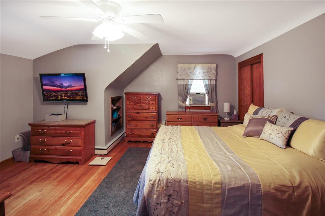 1256 Ridge Avenue Whitehall, PA 18052 - Photo 28 of 43 Hardwood flooring complements a bedroom with a vaulted ceiling and functional window unit.
