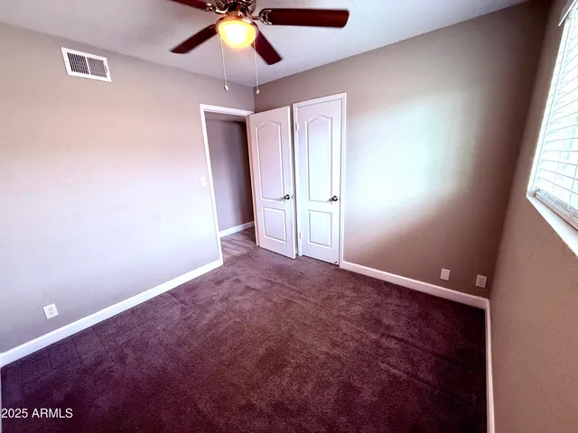 a bathroom with a granite countertop toilet sink and mirror