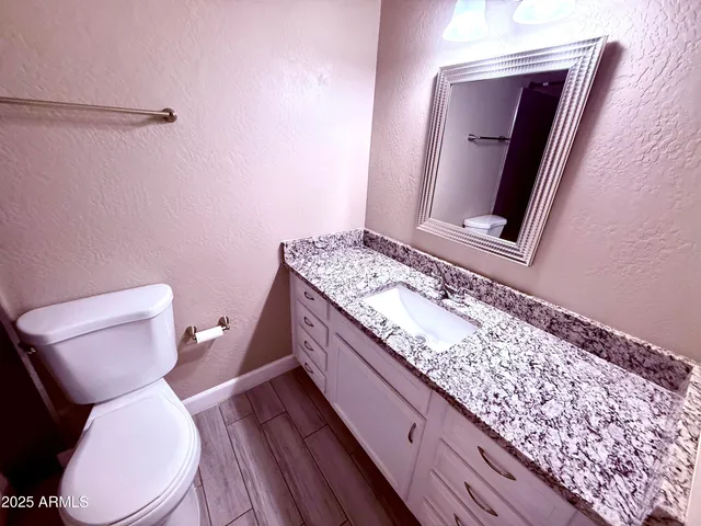 a toilet sitting next to a wooden cabinet