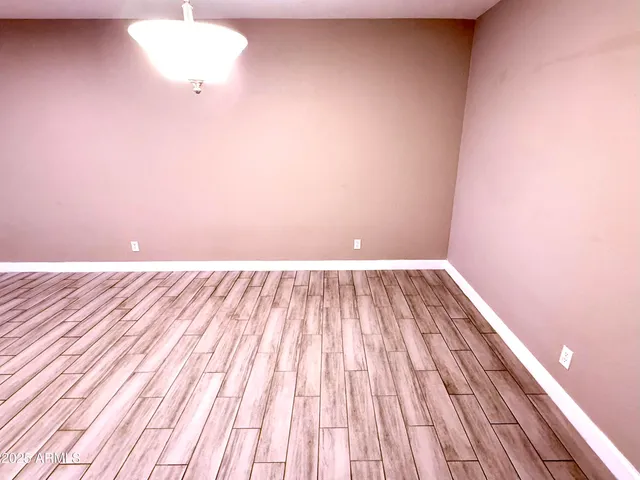 a view of a room with wooden floor and a ceiling fan