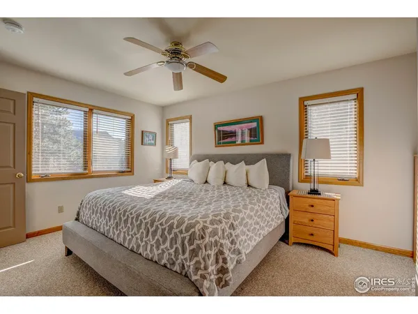 a bedroom with a bed a dresser next to a window