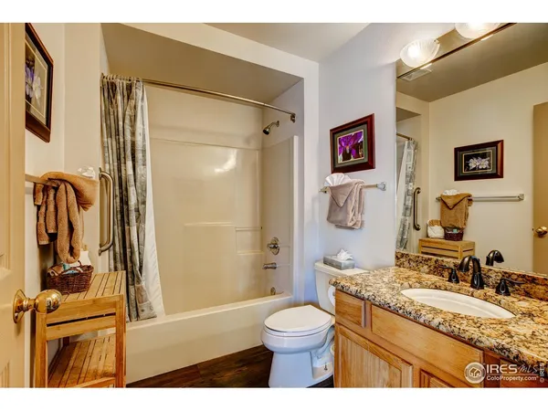 a bathroom with a granite countertop sink toilet and shower