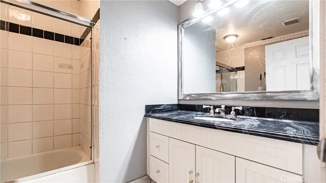 a bathroom with a granite countertop sink and a mirror