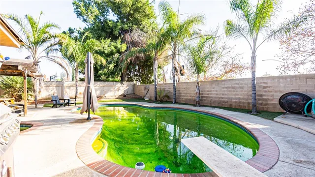 a view of a swimming pool with a chair and tables in the patio