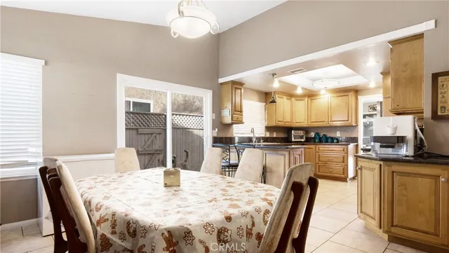a kitchen with stainless steel appliances kitchen island granite countertop a table chairs and a refrigerator