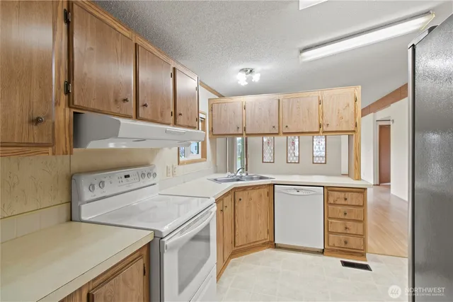 a kitchen with a stove sink and cabinets